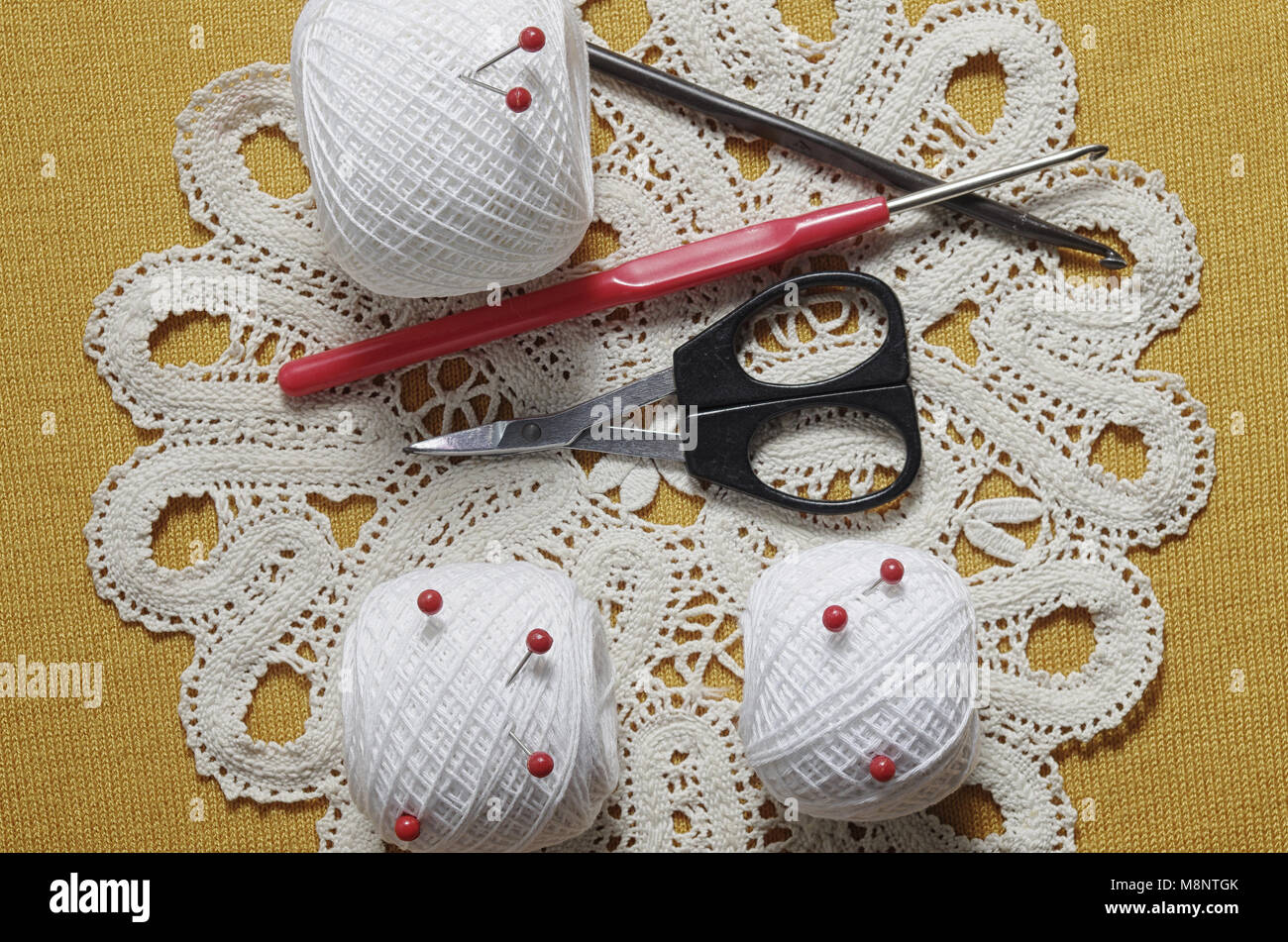 Objects for sewing. Scissors and pins. Hanks thread on mat. Pins and ...