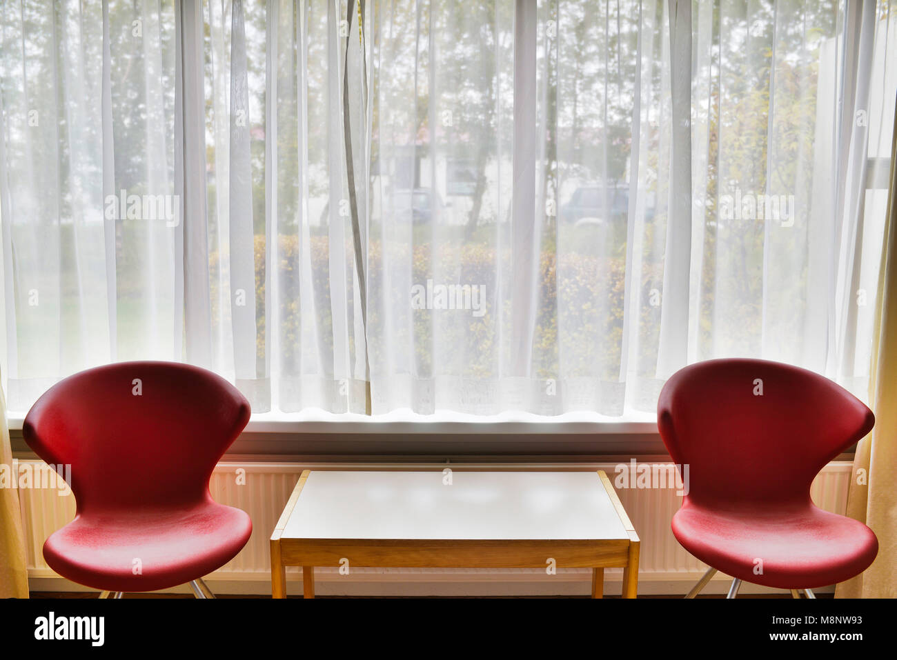 Two empty chairs in front of a big window Stock Photo