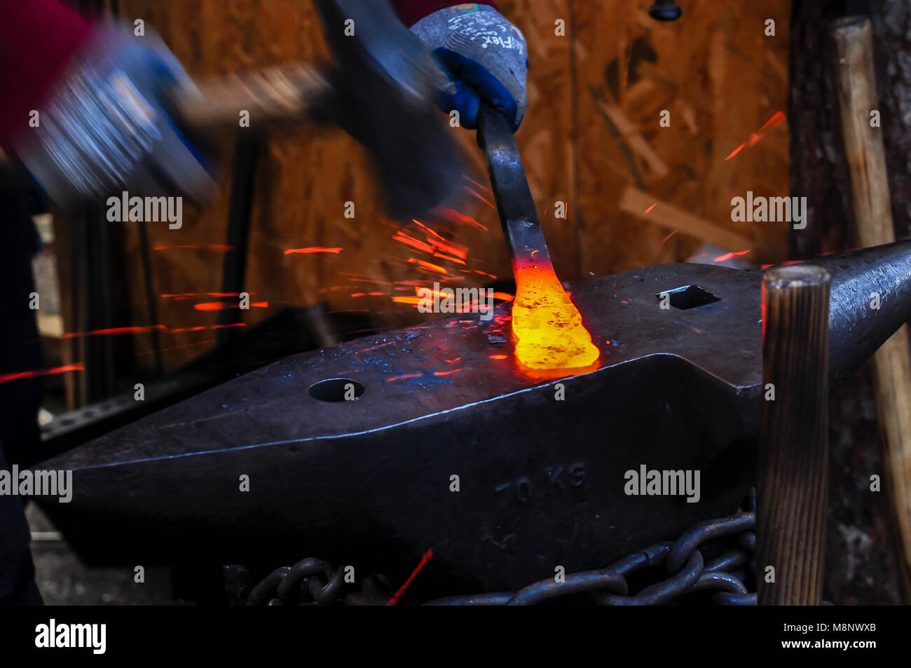Blacksmith manually forging the molten metal Stock Photo