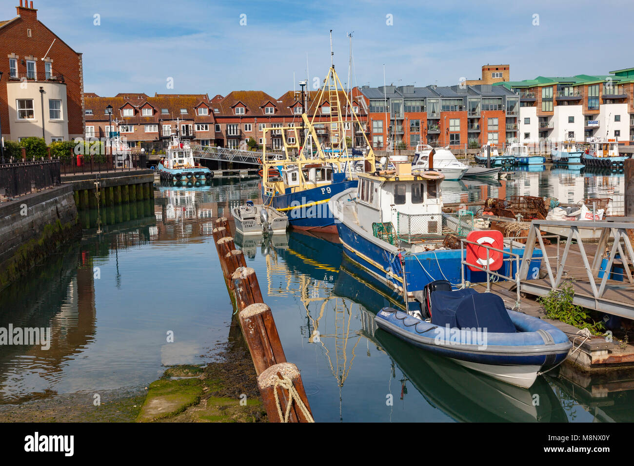 Views across the docks in Old Portsmouth, with fishing boats, and tug boats moored, Portsmouth, Hampshire, UK Stock Photo