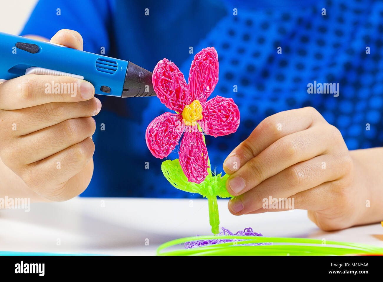 Kid hands creating with blue 3d printing pen Stock Photo - Alamy