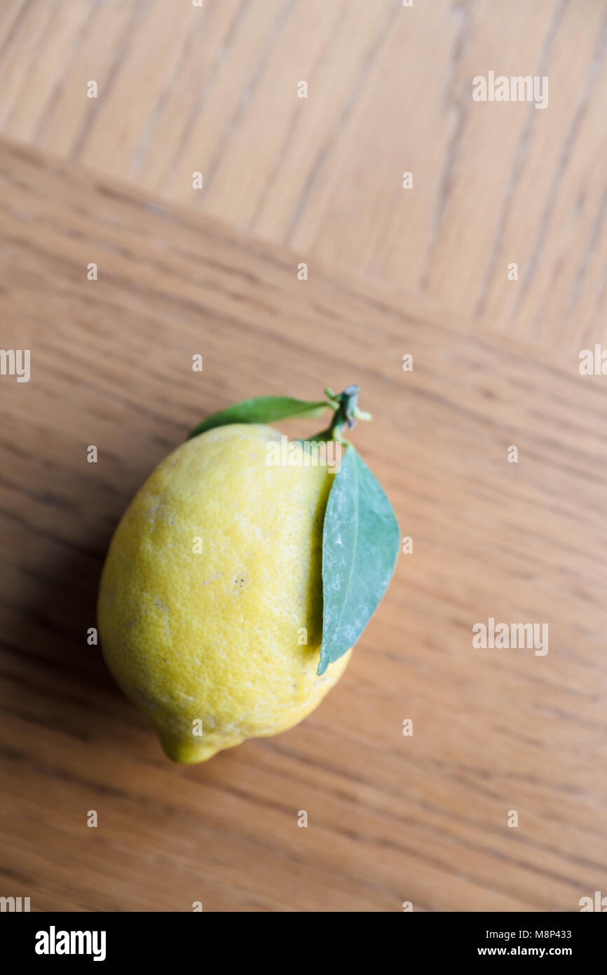 Lemon with leaves on a wooden surface Stock Photo