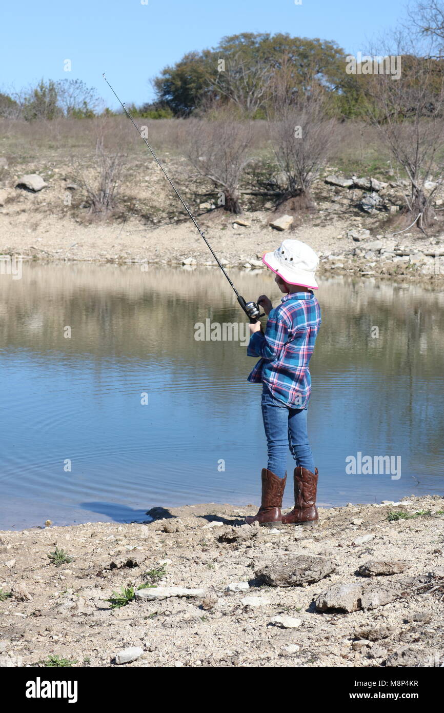 Young girl fishing wearing cowboy boots 