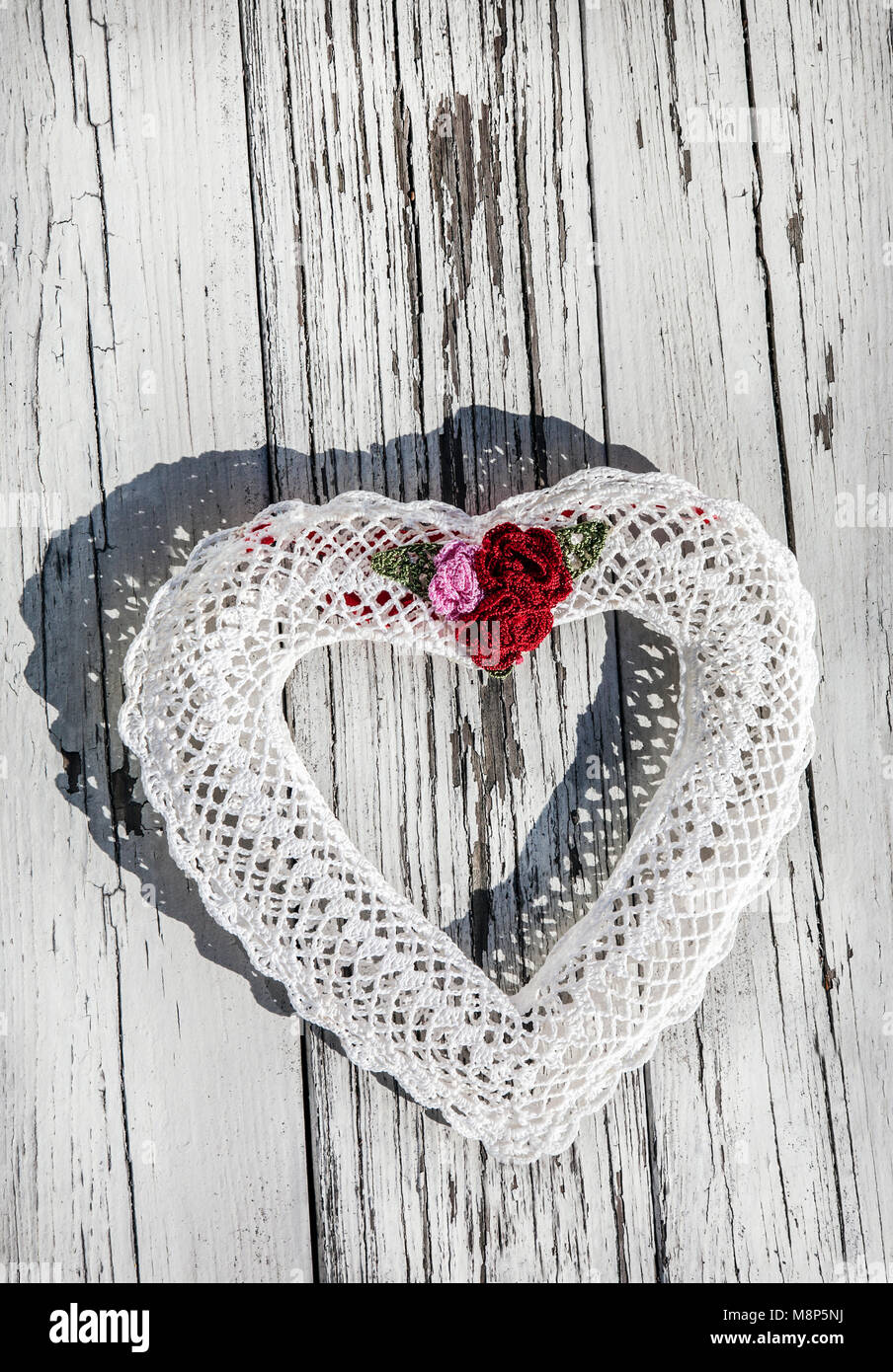 White crochet heart wreath cut out on weathered wood, USA, US vintage Victorian wedding decorations handmade heart Saint Valentine Stock Photo
