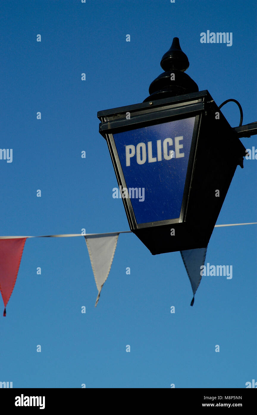 Police blue lantern sign with bunting against blue sky Stock Photo