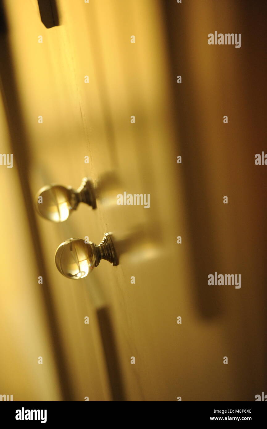 Pair of Transparent round glass door handles on a wardrobe door Stock