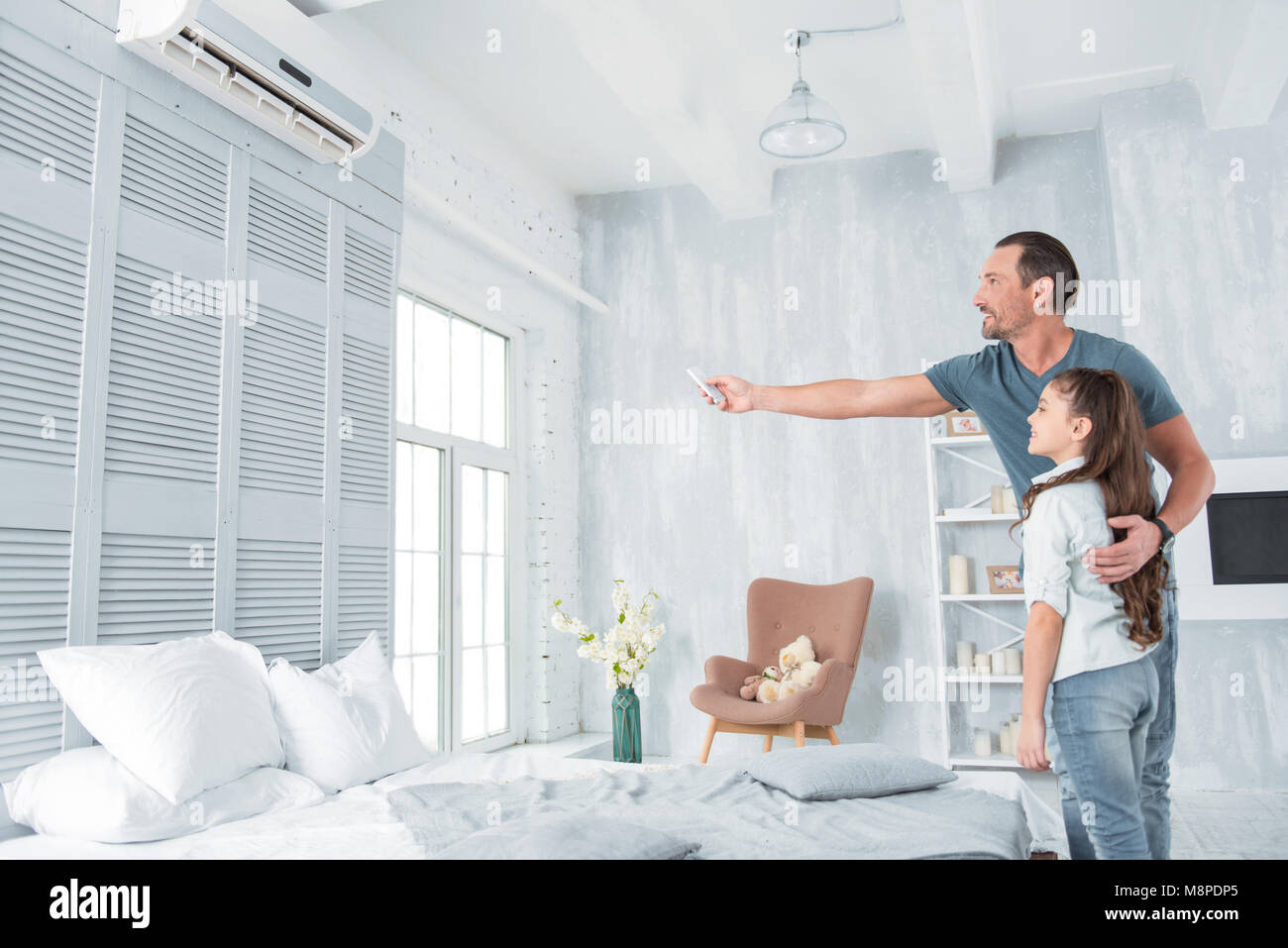 Positive joyful man holding a remote control Stock Photo - Alamy
