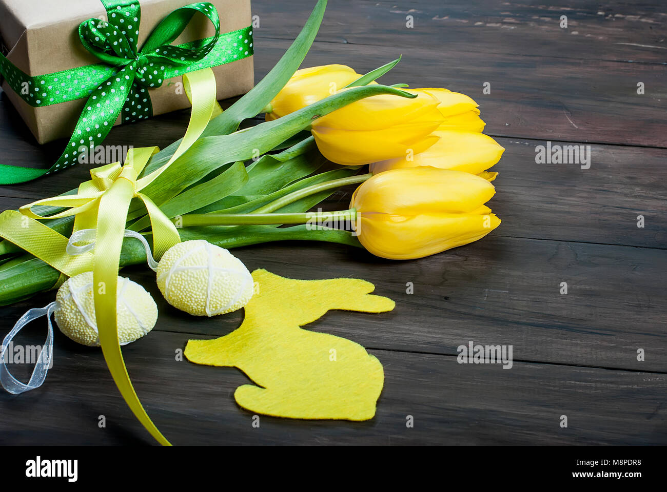 bouquet of yellow tulips and toys chikken easter eggs with a blue ...