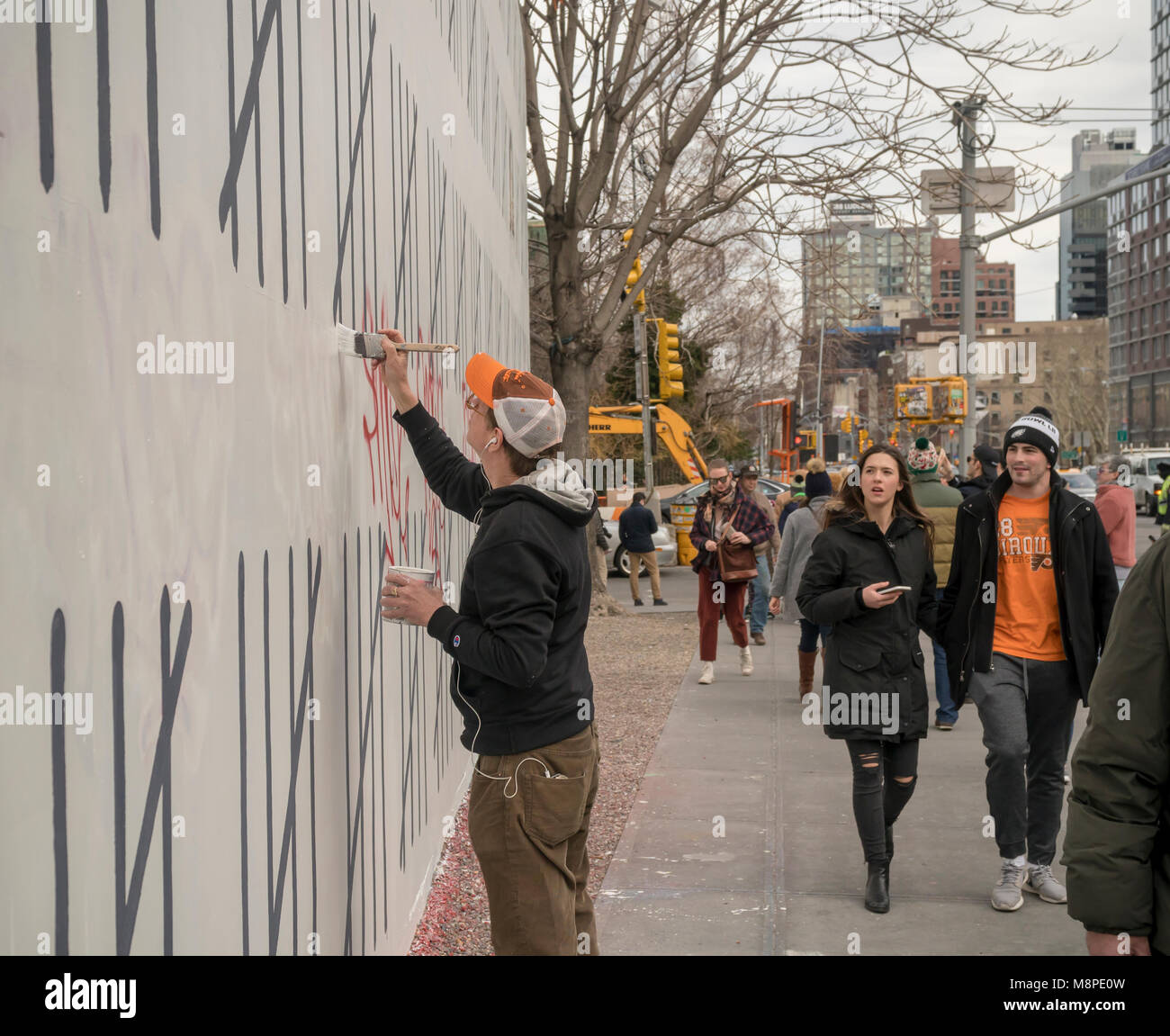 A worker repairs vandalism on the 'Bowery Wall on Houston Street in New York on Saturday, March 17, 2018 home to Banksy's collaboration with the street artist Borf. The work is a tribute to the jailed Turkish Kurdish artist Zehra Dogan who was arrested for painting a work featuring a Kurdish town in ruins after a conflict between the army and Kurdish rebels.  Banksy's work previously appeared in New York on October 2013 when he created a work a day during his one month 'residency'. (Â© Richard B. Levine) Stock Photo