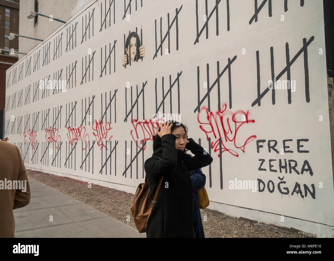 Street art enthusiasts flock to the 'Bowery Wall on Houston Street in New York on Saturday, March 17, 2018 to view and photograph artist Banksy's collaboration with the street artist Borf. The work is a tribute to the jailed Turkish Kurdish artist Zehra Dogan who was arrested for painting a work featuring a Kurdish town in ruins after a conflict between the army and Kurdish rebels.  Banksy's work previously appeared in New York on October 2013 when he created a work a day during his one month 'residency'. (© Richard B. Levine) Stock Photo