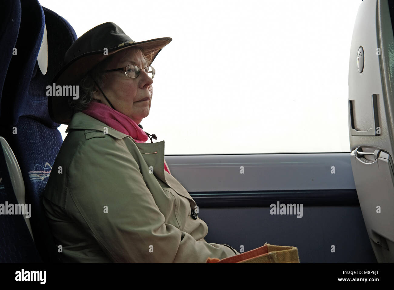 A n older lady travelling on a train. Stock Photo