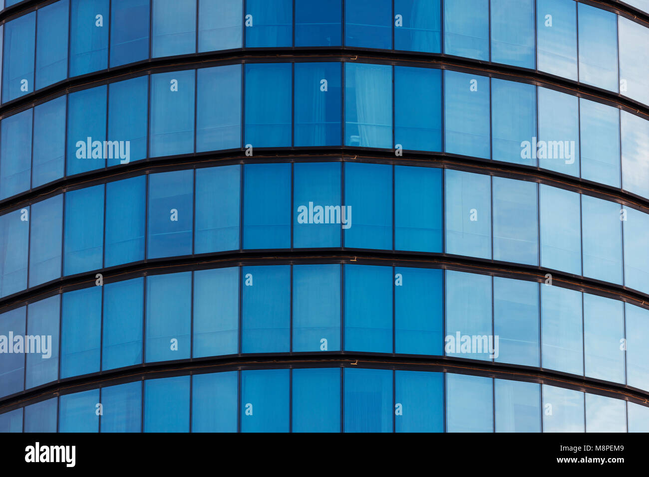 Blue windows of a cylindrical building background texture. Stock Photo