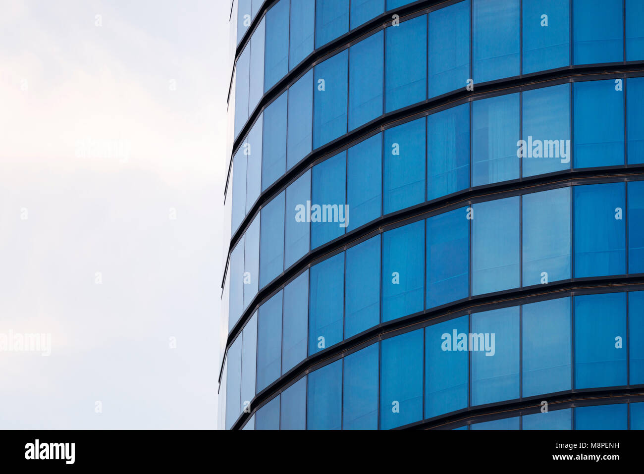 Blue windows of a cylindrical building background texture. Stock Photo