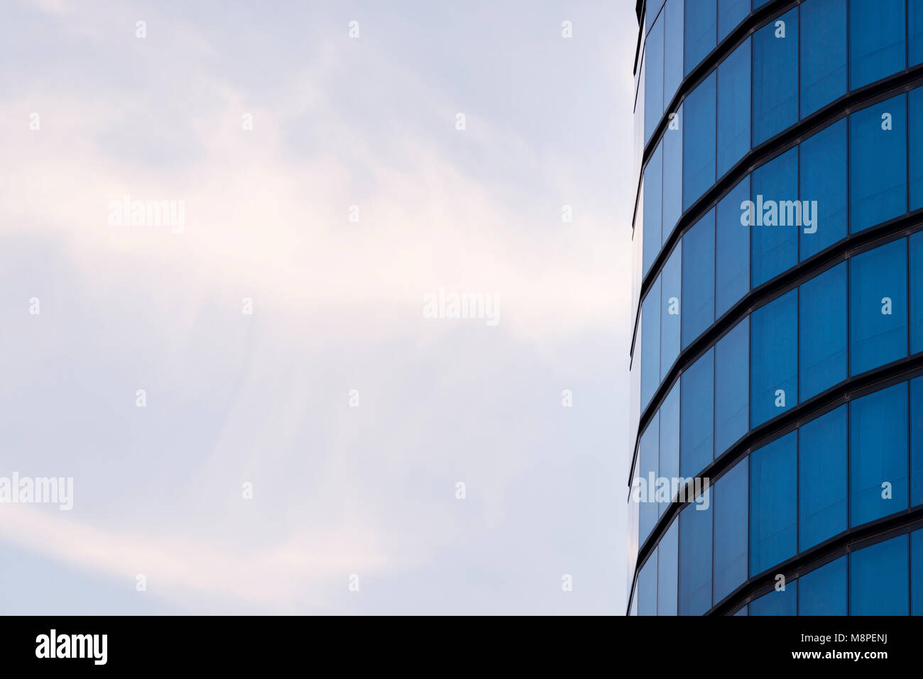 Blue windows of a cylindrical building background texture. Stock Photo
