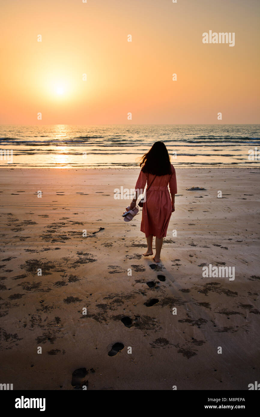 girl walking on beach at sunset