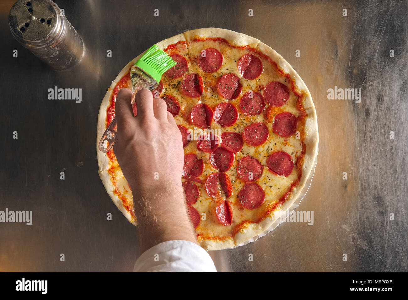 Oiling with garlic oil ready pizza Stock Photo Alamy