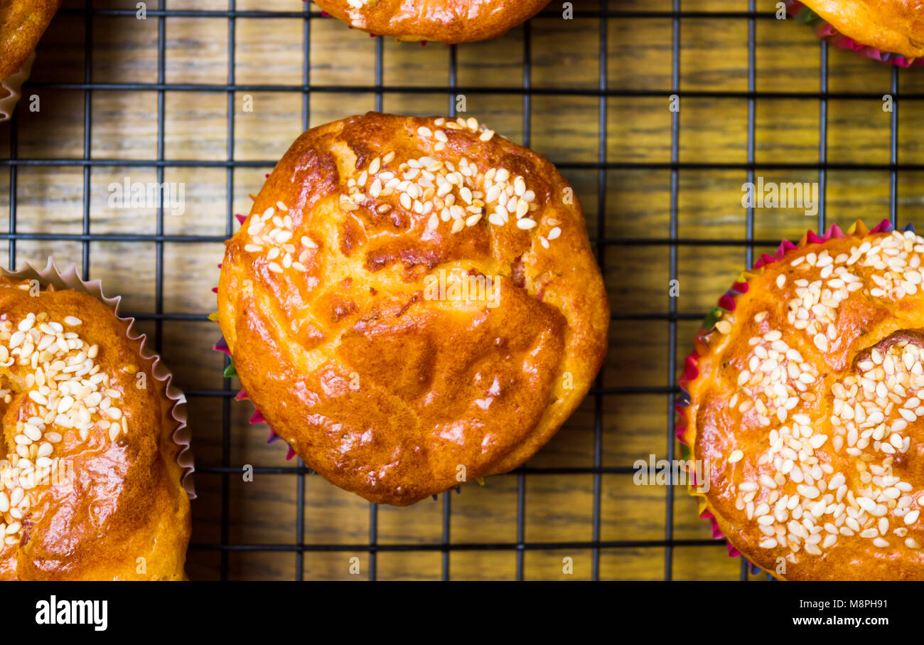 Homemade sesame muffins with seeds and grains on a baking net Stock Photo