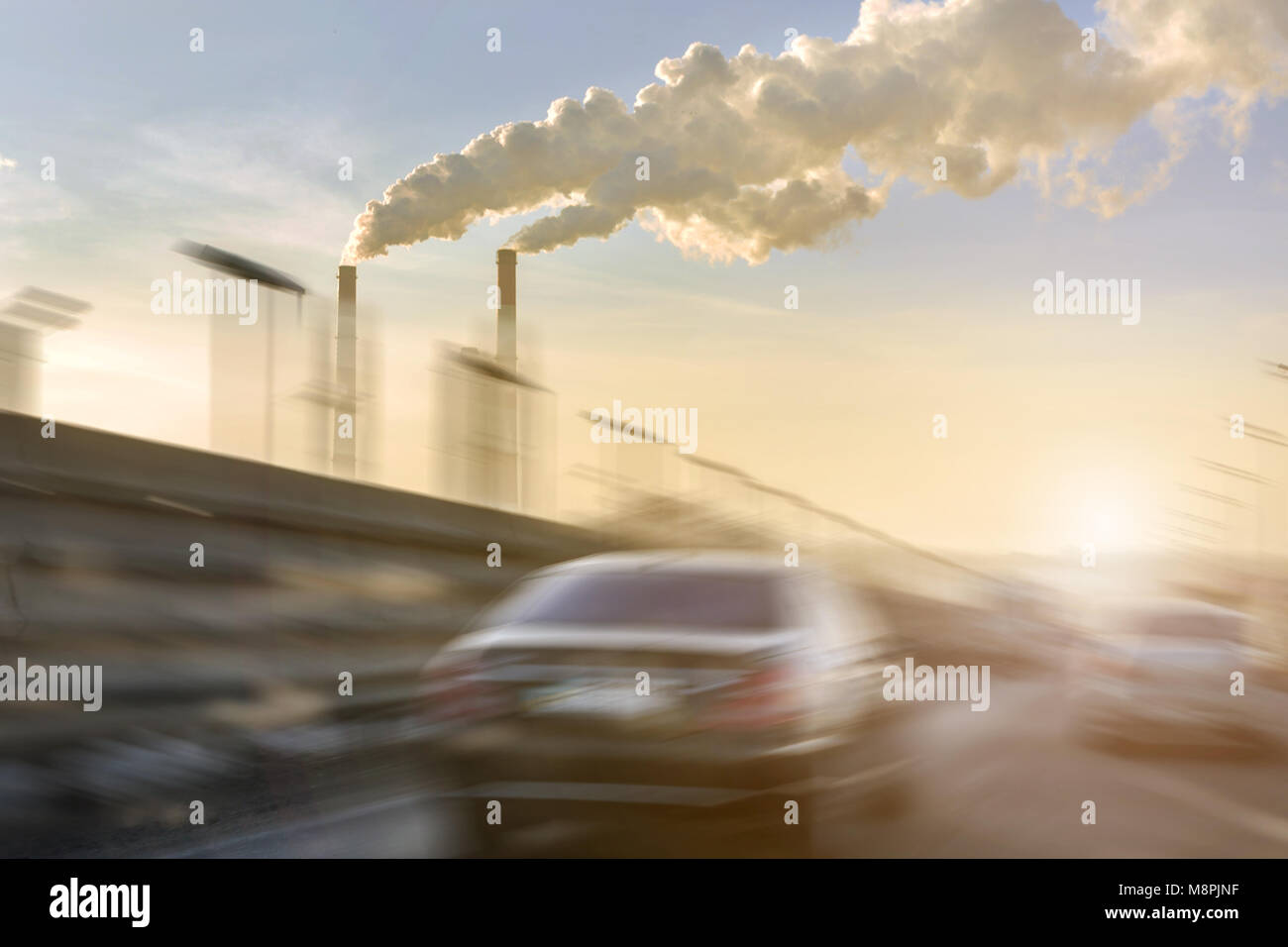 Cars moving fast on city highway. Smoking factory pipes with white