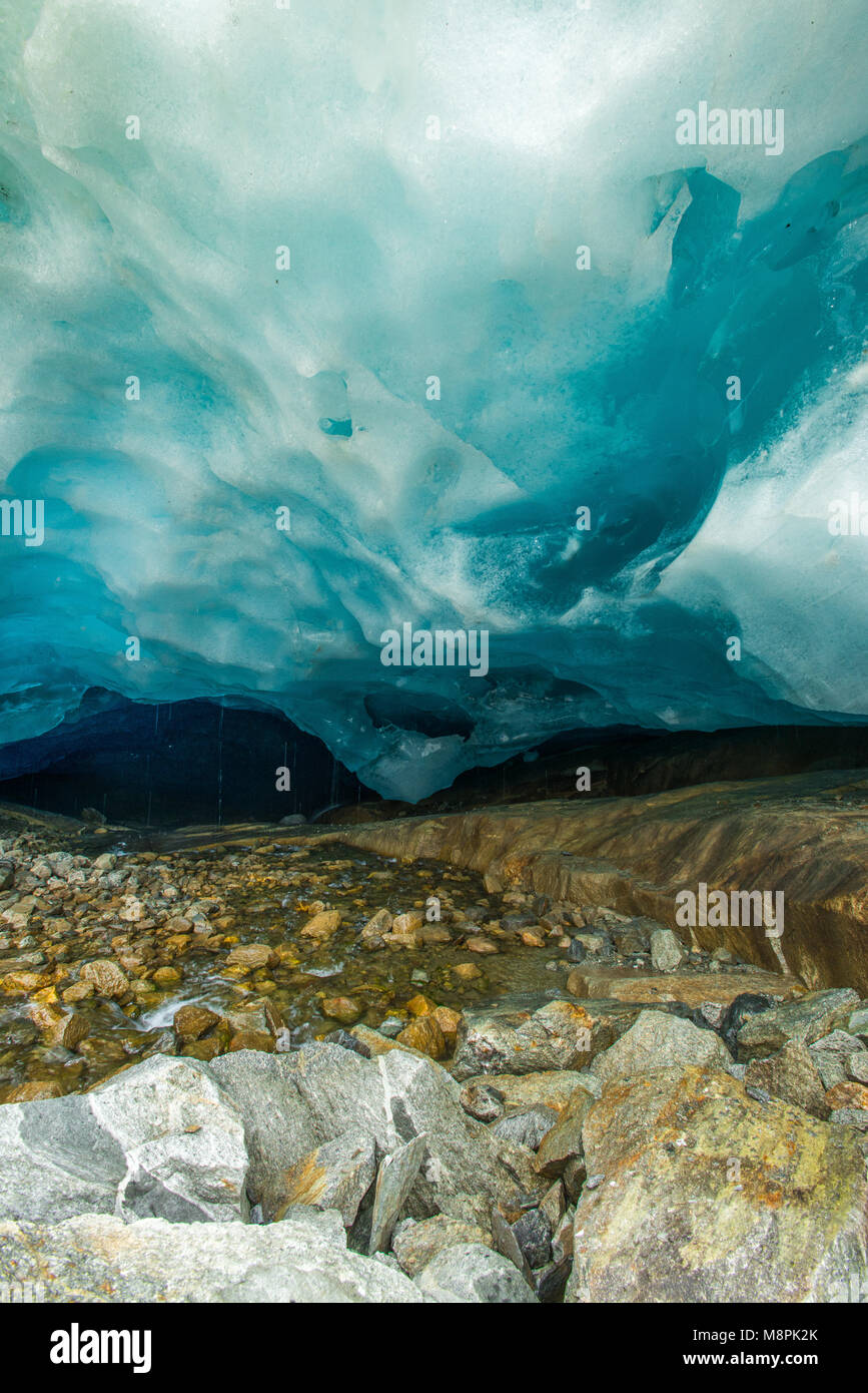 Deep blue ice at the bottom of Aletsch glacier, longest glacier in Europe. Cave, stream, icefield, melting ice, exploring the shrinking sheet. Stock Photo