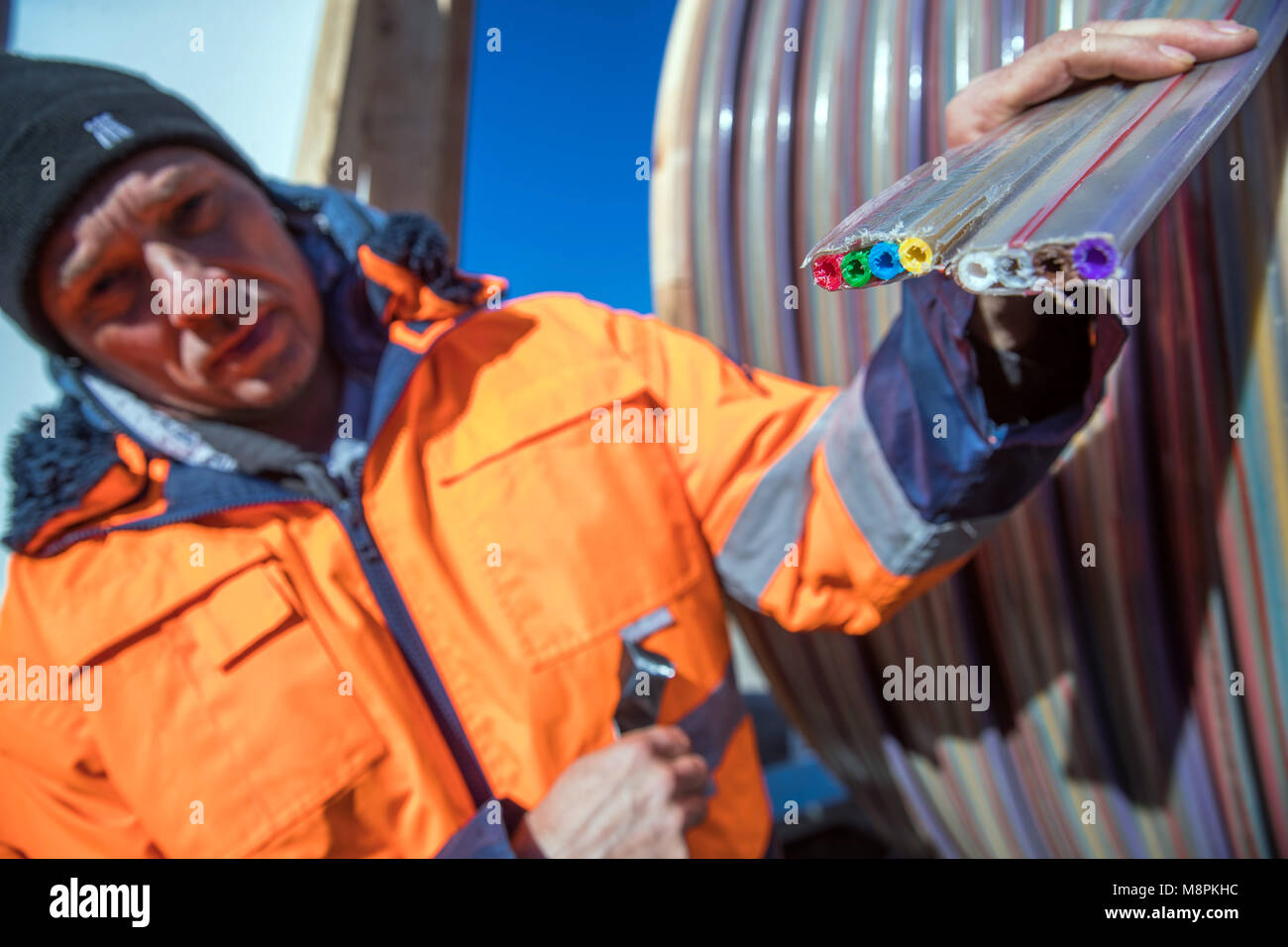 19 March 2018, Germany, Siggelkow: A man works on a construction site in the Ludwigslust-Parchim community, where extensive development of the broadband has now begun. Broadband company 'Wemcom Breitband', energy provider 'Wemag' and the municipal utilities of Schwerin are cooperating to expand the region's digital infrastructure. Photo: Jens Büttner/dpa-Zentralbild/dpa Stock Photo