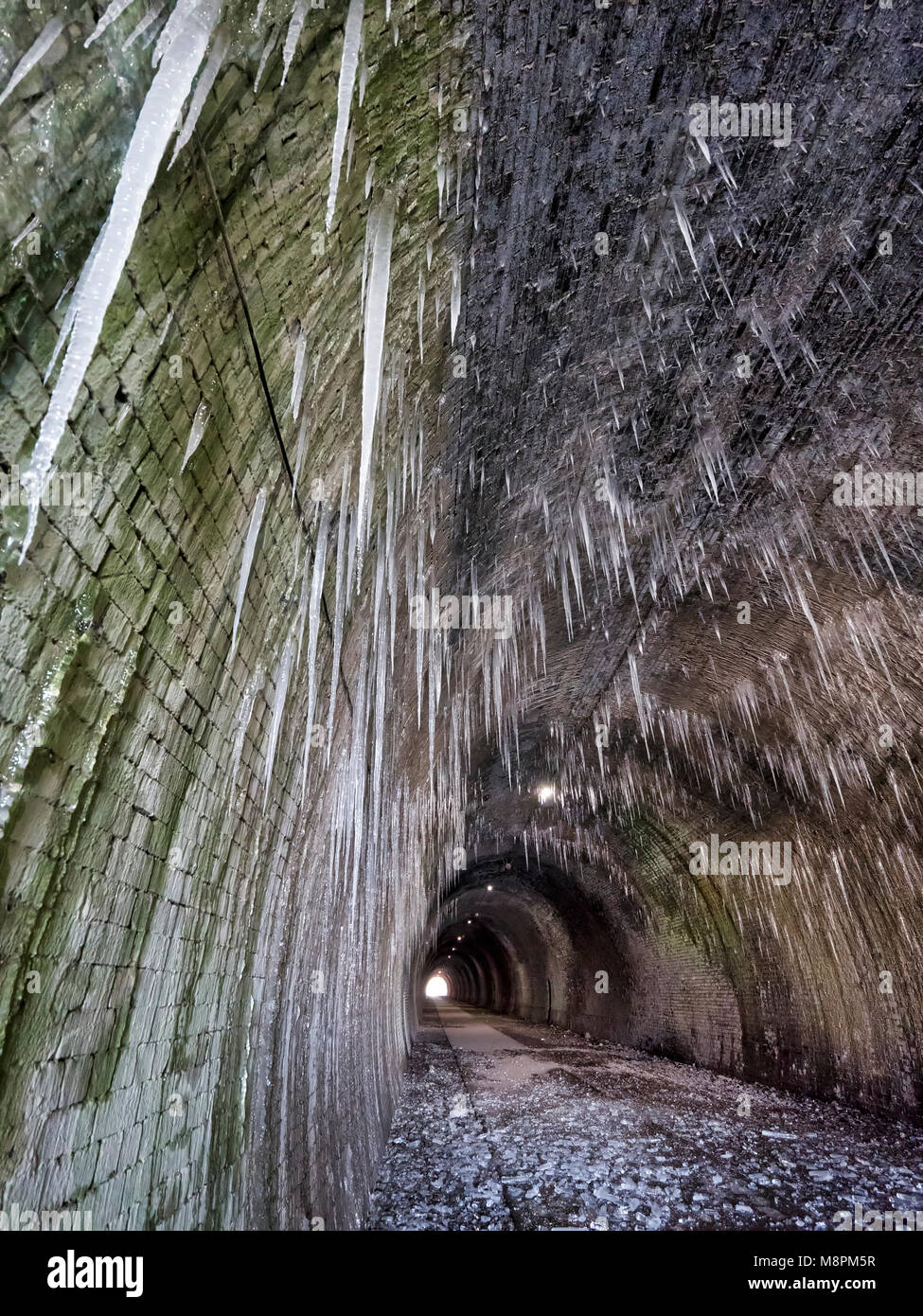 Tissington Trail railway walk, Peak District National Park, UK. 19th March, 2018. UK Weather: thawing icicles up to 6ft long pose a danger to walkers when they fall inside the frozen Ashbourne Tunnel on the Tissington Trail railway walk in the Peak District National Park, Derbyshire, England, UK Credit: Doug Blane/Alamy Live News Stock Photo