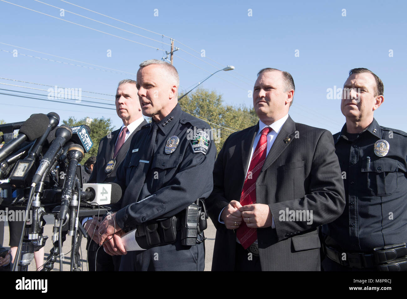 Austin, Texas, Interim Police Chief Brian Manley, FBI Special Agent Christopher Combs (r) and ATF chief Fred Milanowski speak to press as they work at the crime scene where a fourth package bomb in three weeks exploded Sunday night on a southwest Austin roadside, injuring two men. Police say a possible 'trip wire' was used to detonate the device. Stock Photo