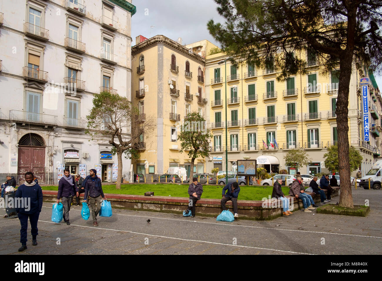 Men whiling away the afternoon on a square in a central square, Piazza Principe Umberto, in Naples Stock Photo