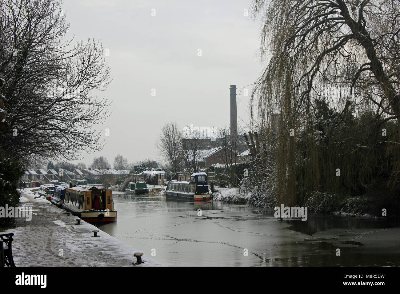 The Leeds and Liverpool canal in the Burscough has frozen over and there has been a light snow shower to give a bit more winteriness to the scene. Stock Photo