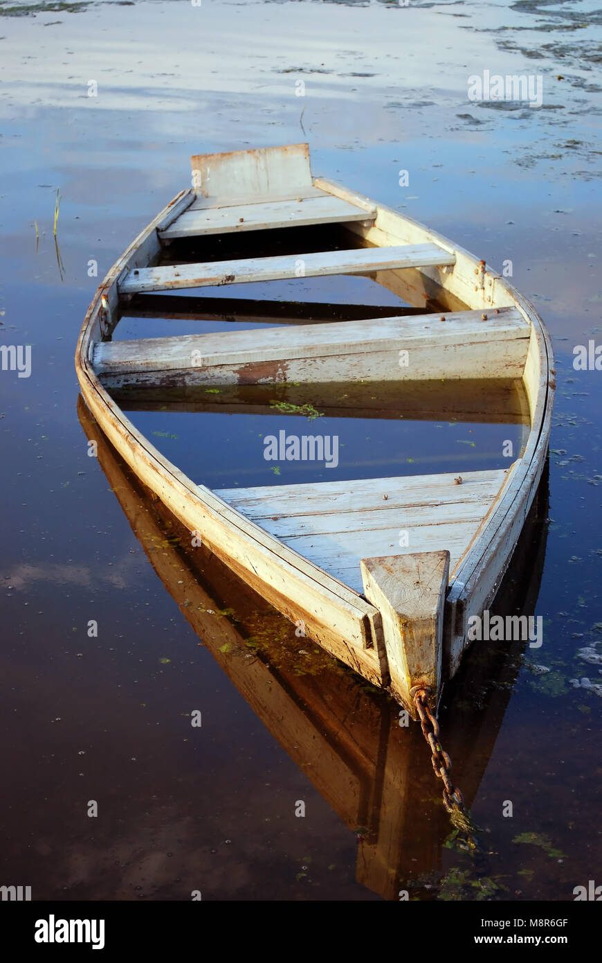 The flooded wooden boat on river bank Stock Photo - Alamy
