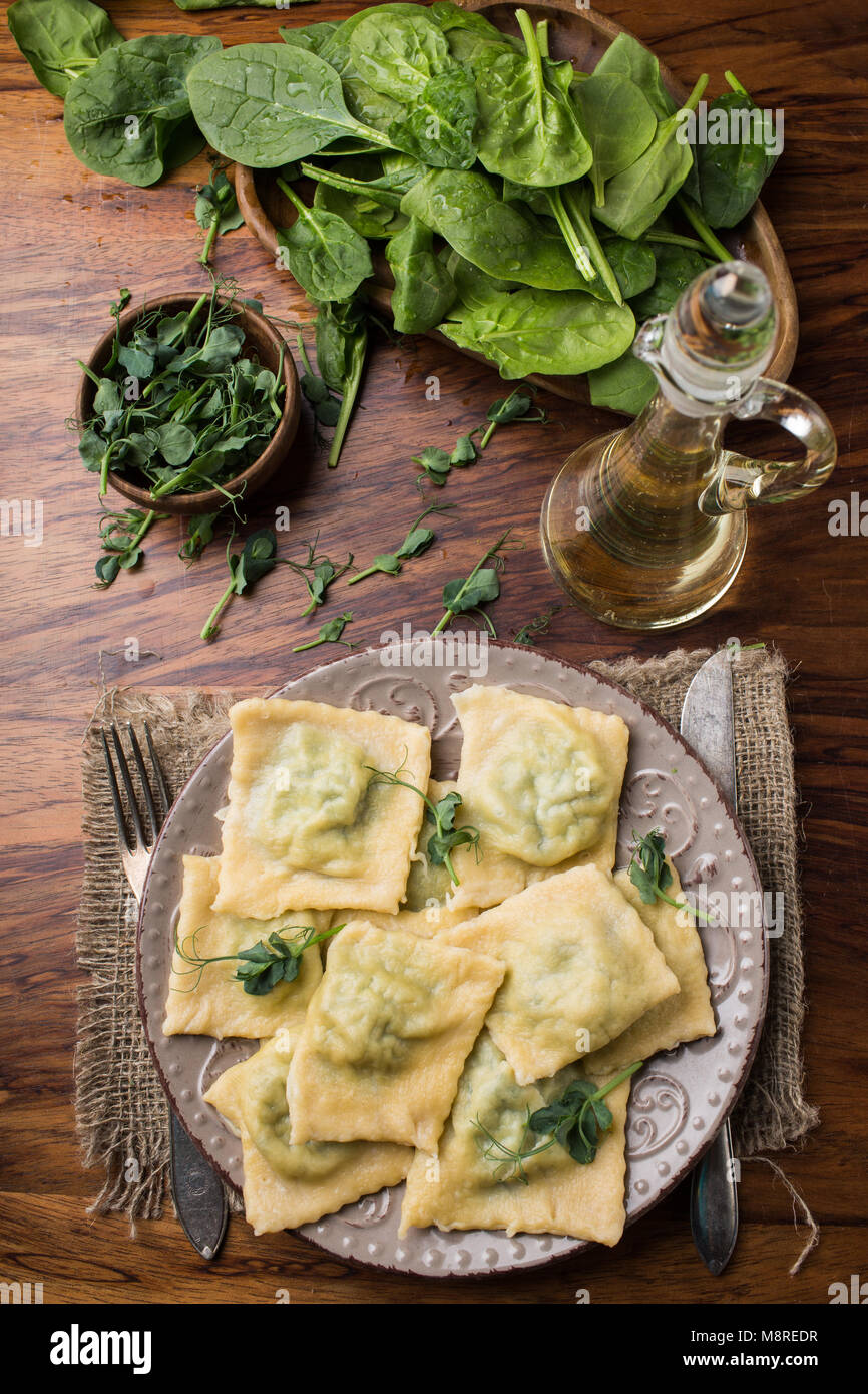 ready ravioli in a plate, spinach, olive oil in a jar Stock Photo Alamy