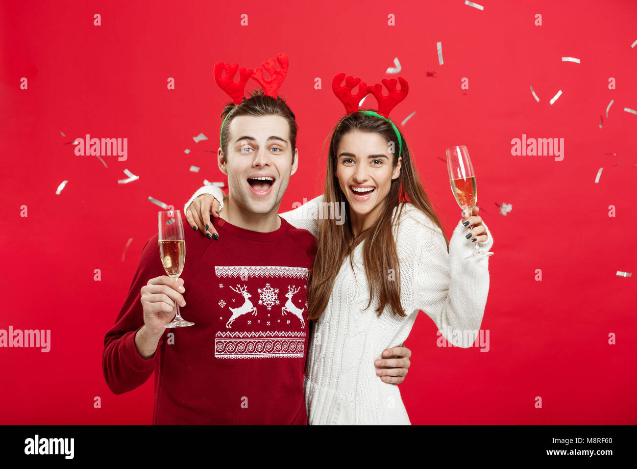 Christmas Concept Happy caucasian man and woman in reindeer hats