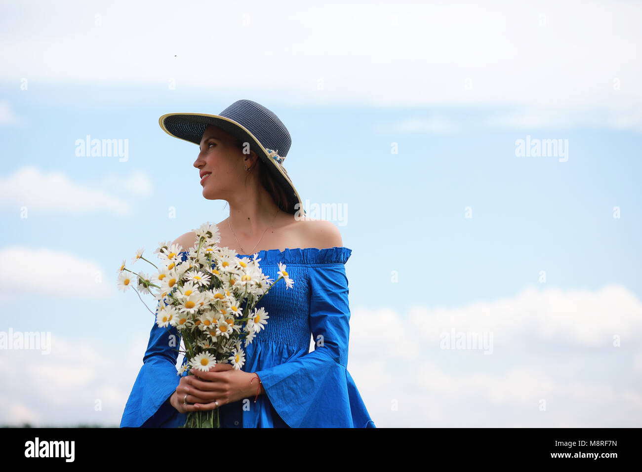 Young cute girl in a hat in a field at sunset Stock Photo - Alamy