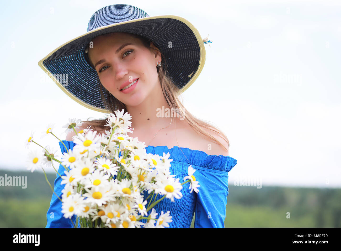 Young cute girl in a hat in a field at sunset Stock Photo - Alamy