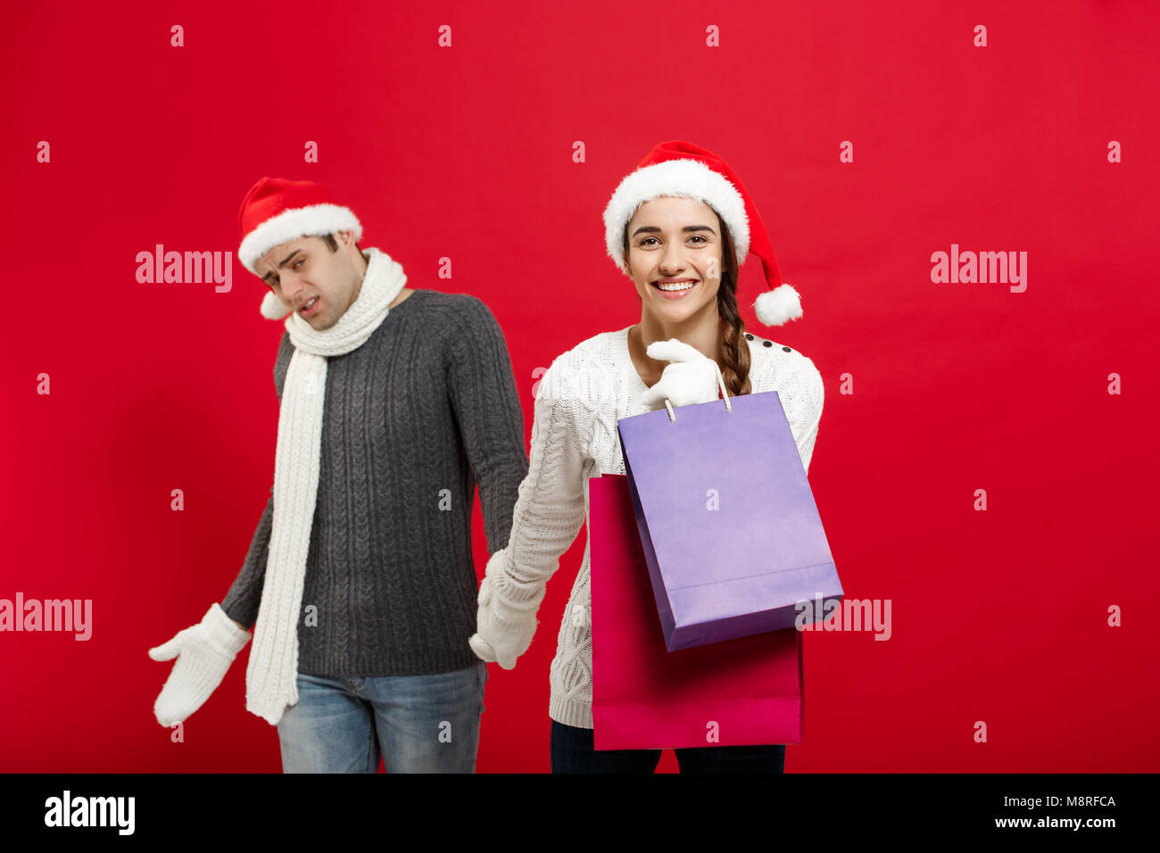 Christmas Concept - Beautiful girlfriend force her boyfriend to  Stock Photo