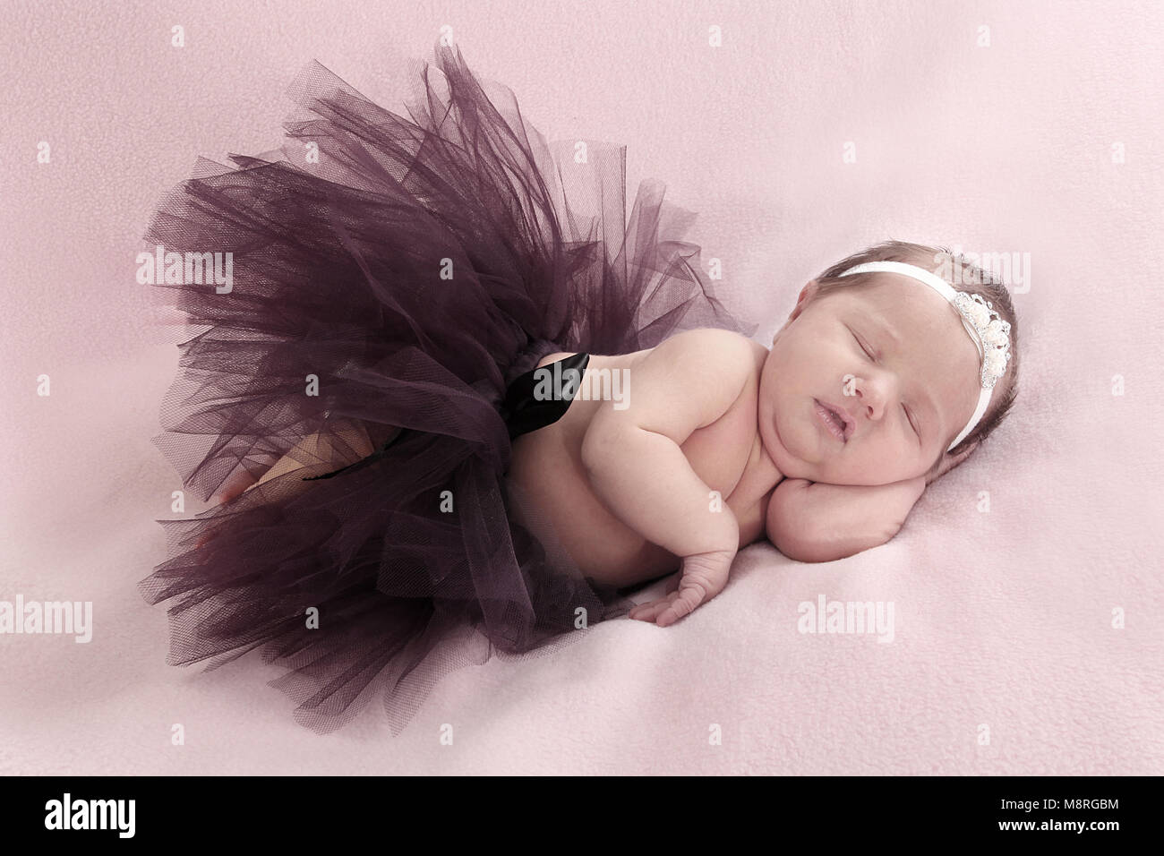 cutie newborn baby girl in tutu sleeping on soft blanket in nursery