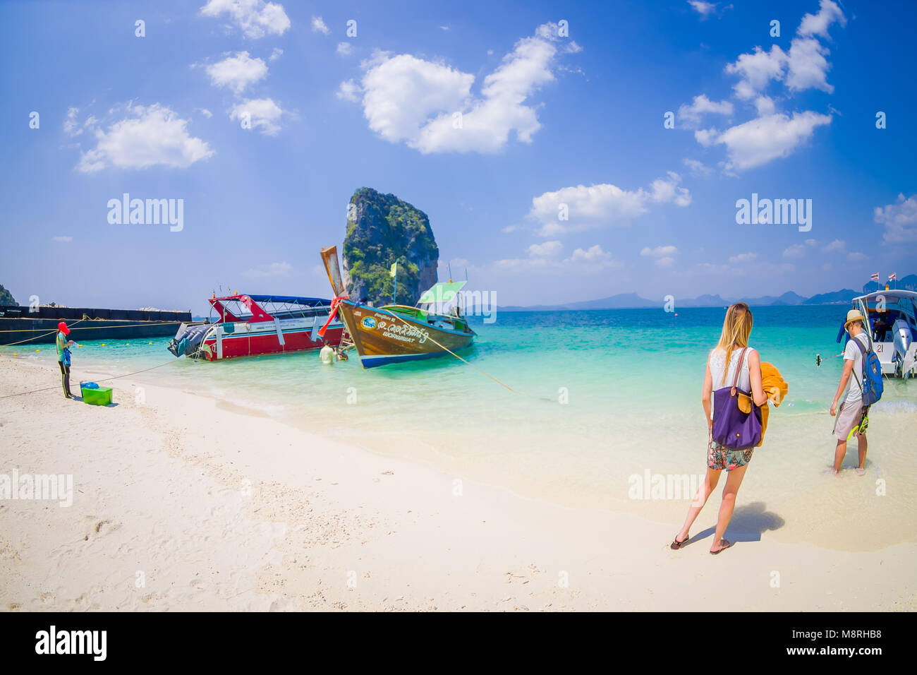 PODA, THAILAND - FEBRUARY 09, 2018: Beautiful outdoor view of unidentified people in a white sand close to long tail boat on Phra nang island in a gorgeous sunny day and turquoise water Stock Photo