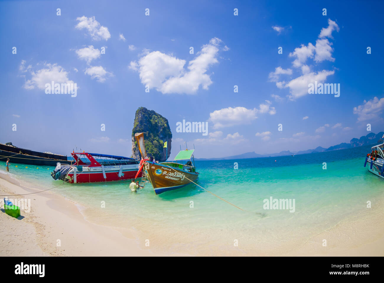 PODA, THAILAND - FEBRUARY 09, 2018: Beautiful outdoor view of unidentified people in a white sand close to long tail boat on Phra nang island in a gorgeous sunny day and turquoise water Stock Photo