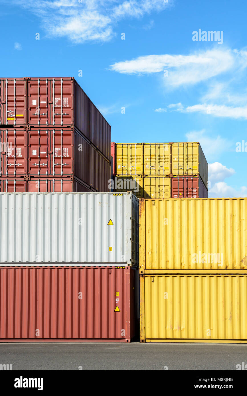 Dry cargo containers of different colors stacked in a shipping yard