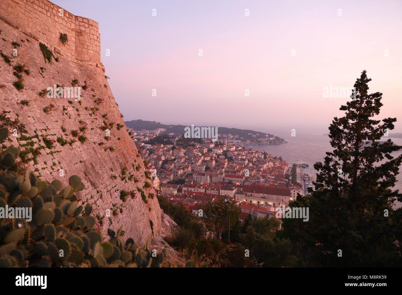 High angle view of cityscape by sea against sky during sunset Stock Photo