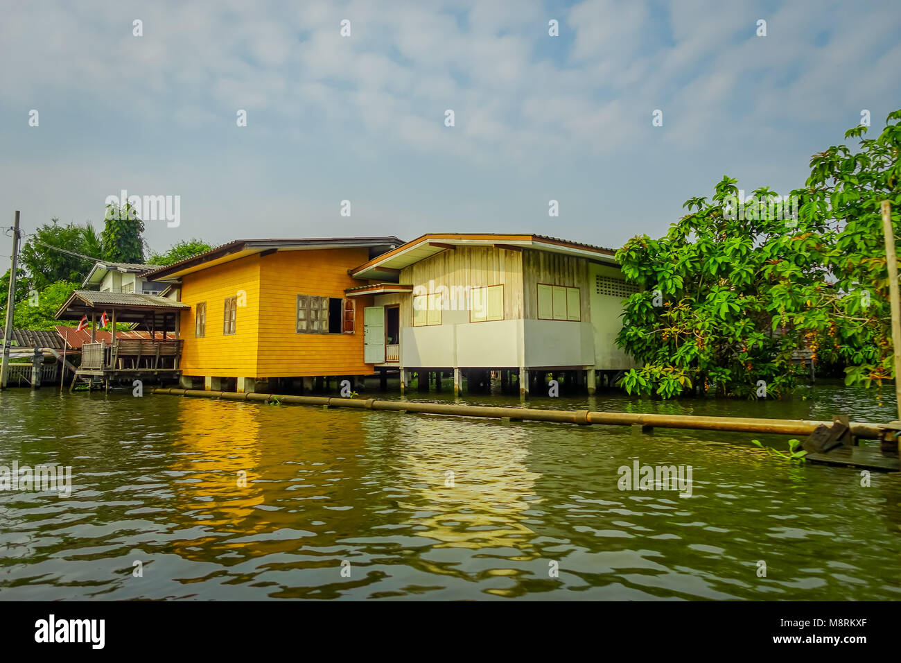 Outdoor view of floating wooden house with a pipeline on the