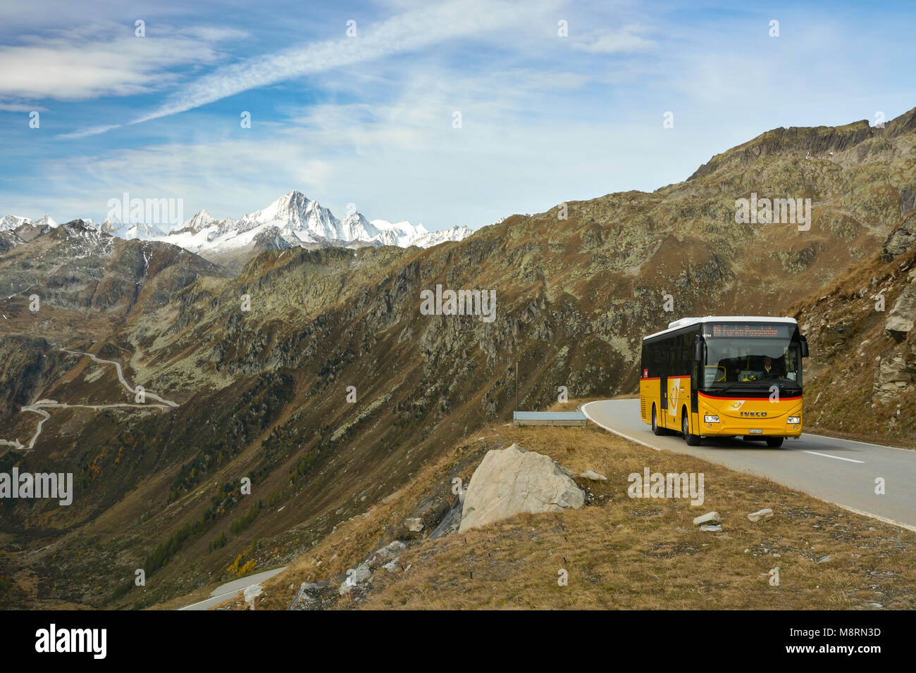 FURKAPASS, SWITZERLAND - OCTOBER 2017 - Typical yellow Postbus in Switzerland on high altitude Furka pass road. The highest point of road reaches 2429 Stock Photo