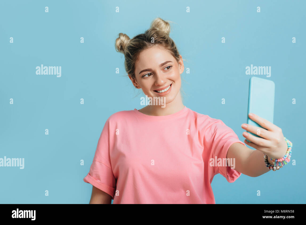 woman making photo on her smartphone blue background Stock Photo