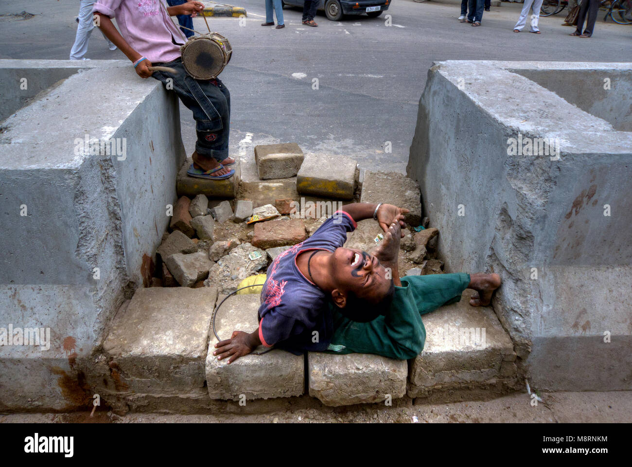 New Delhi, India: A child performs in an exercise of contortion on the road in New Delhi Stock Photo