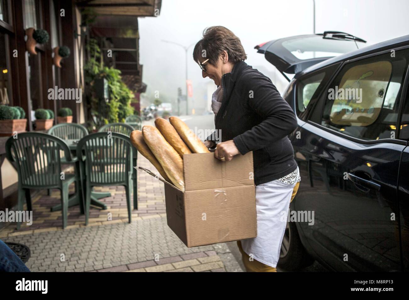 Eine Bäckerin bringt Baguettes und Croissants in das Hotel de France in der belgischen Stadt Kleinstadt Bouillon. Die Frau fährt jeden morgen mit ihre Stock Photo