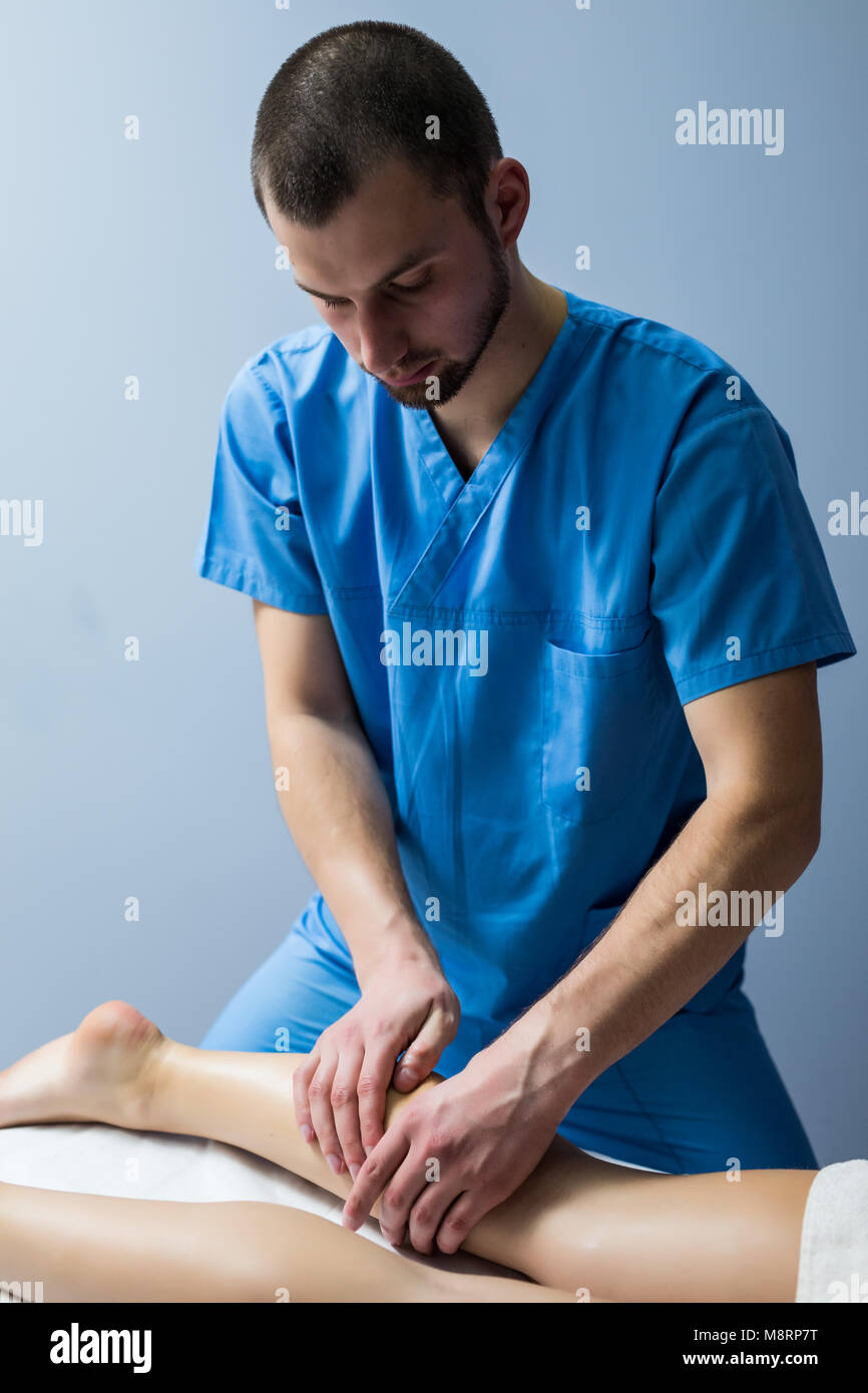 Detail of hands massaging human calf muscle.Therapist applying pressure