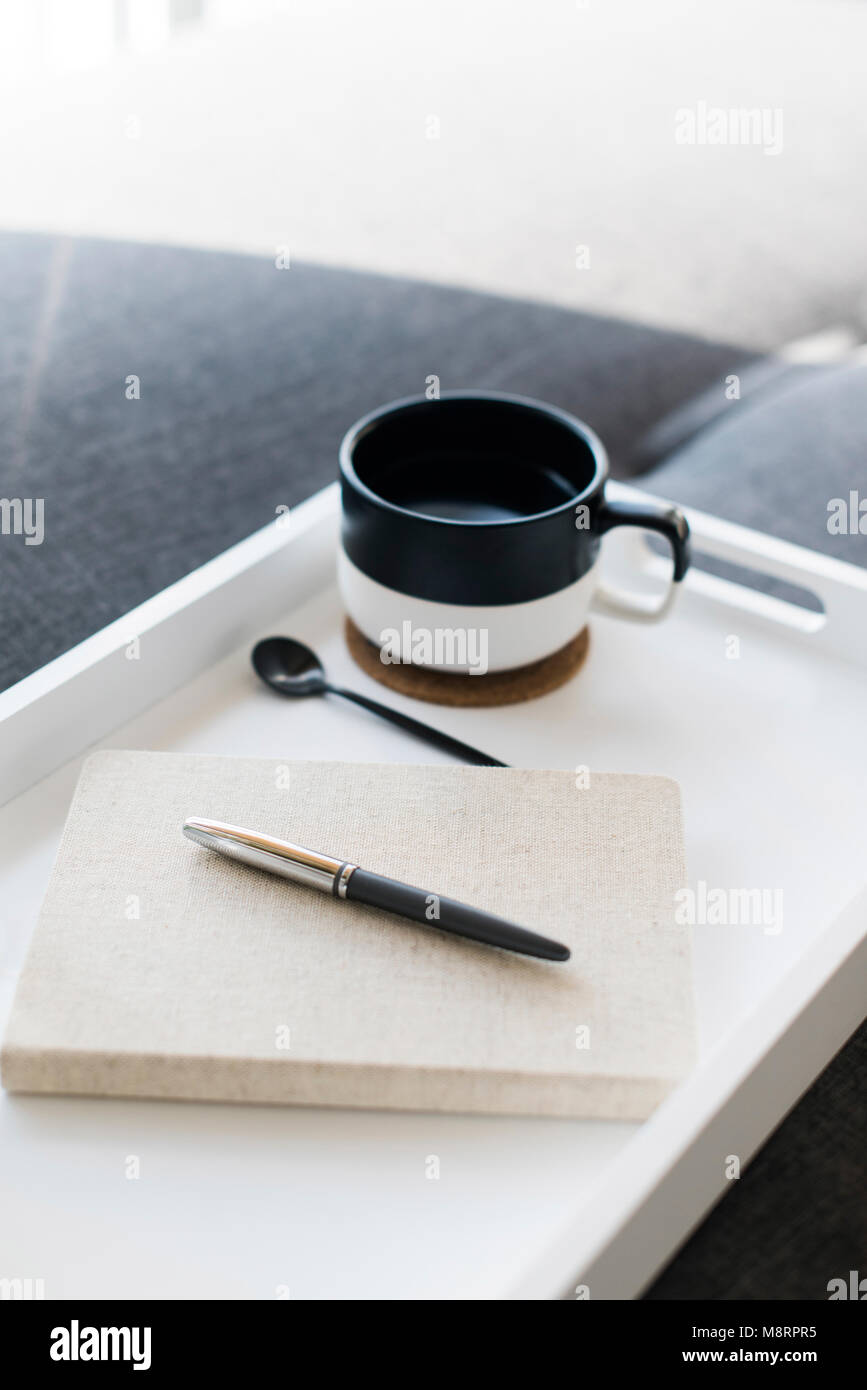 Close-up of pen on diary by coffee cup in tray Stock Photo
