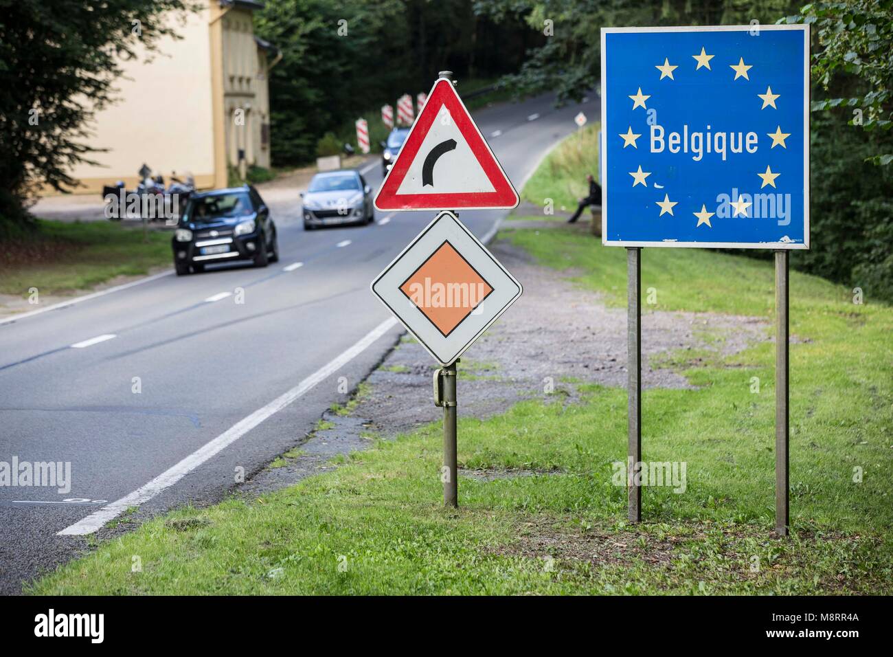 Ein blaues Schild mit dem Schriftzug Belgique umrandet von goldenen EU-Sternen symbolisiert den Grenzübertritt nach Belgien auf dieser Landstrasse in  Stock Photo