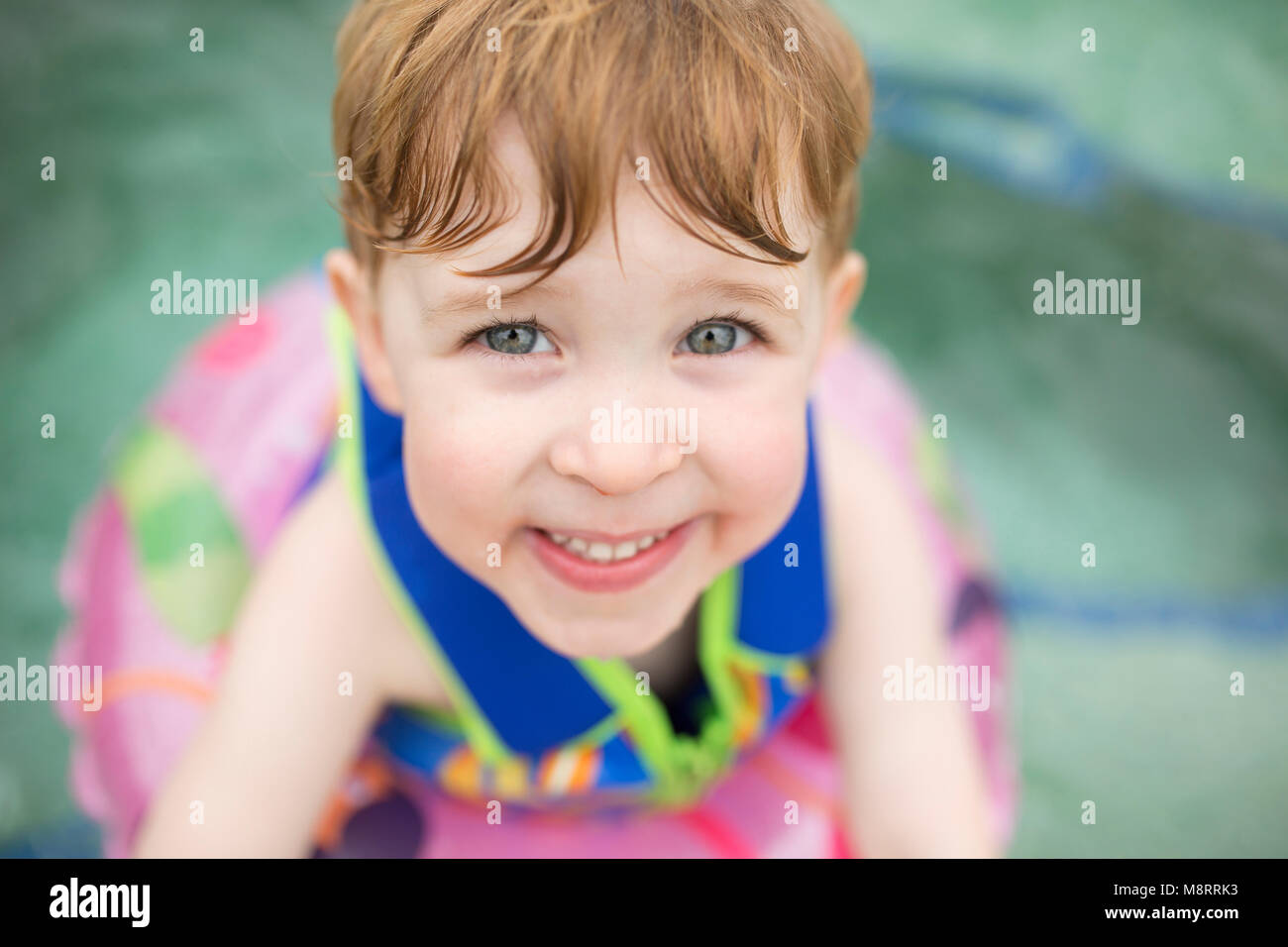 High angle portrait of smiling boy with inflatable ring floating on ...