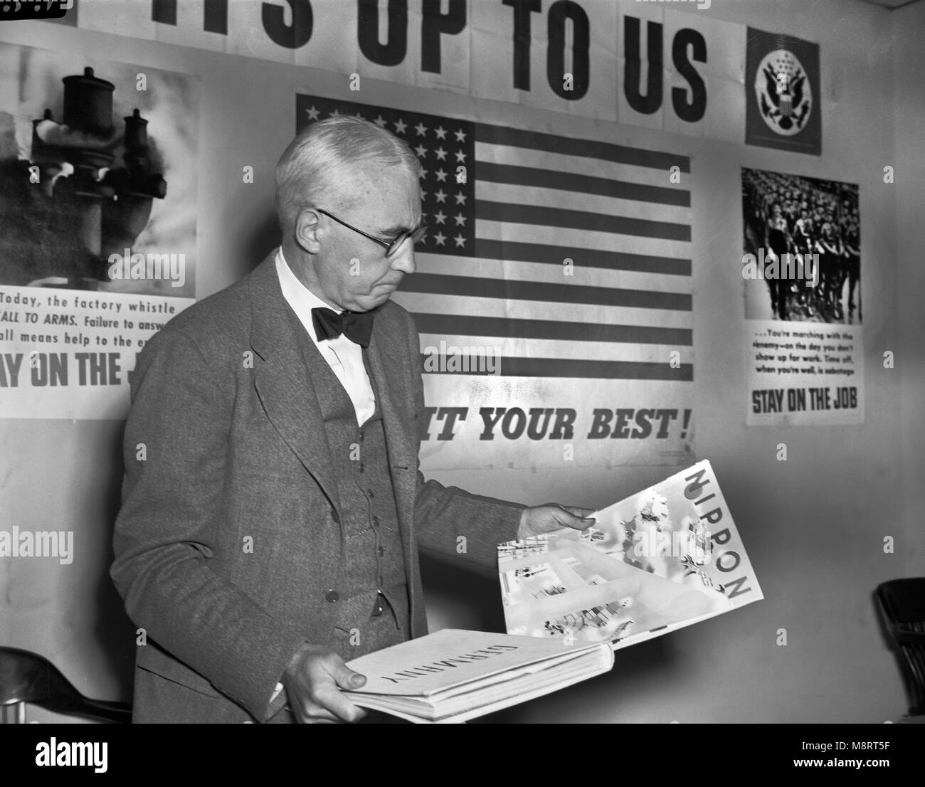 Elmer Davis, Director of Office of War Information, Examining Nazi and Japanese Propaganda Organs at Press Conference to show Material the Axis is Distributing in Neutral Countries, Office of War Information, March 6, 1943 Stock Photo