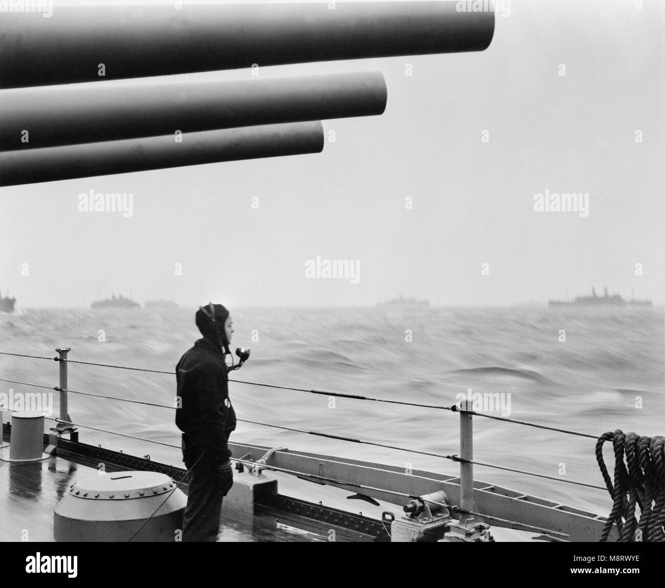 U.S. Navy Sailor on Naval Vessel Keeping Alert Watch over Merchant Ships Delivering Vital Supplies to U.S. and Allied Forces in Europe, Atlantic Ocean, Office of War Information, 1940's Stock Photo